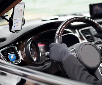 a man in the black gloves is driving a car